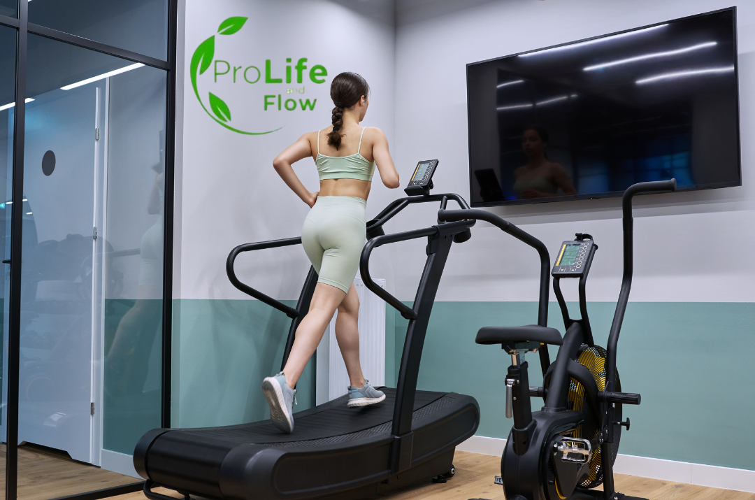 Mulher correndo em uma esteira ao lado de bicicleta ergométrica e elíptico, representando os melhores equipamentos de cardio para treinar em casa